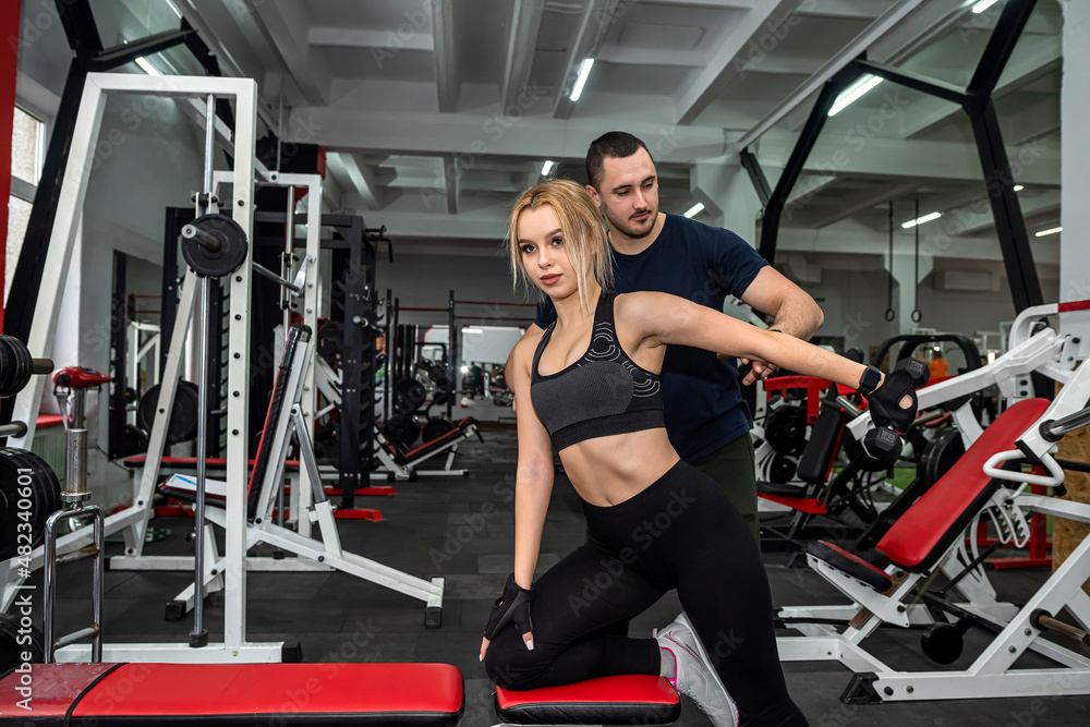 happy healthy friendly male trainer conducts personal training with beautiful client.