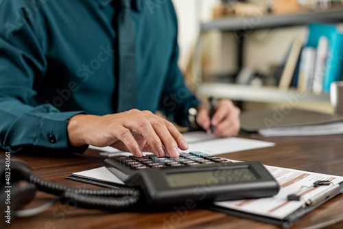 Business hand pressing on calculator for calculating cost estimating.