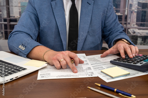 wise male businessman working with important documents at office desk.