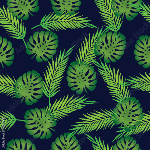 Seamless pattern with the image of palm leaves and monstera on a dark blue background. Tropical print of exotic plants.