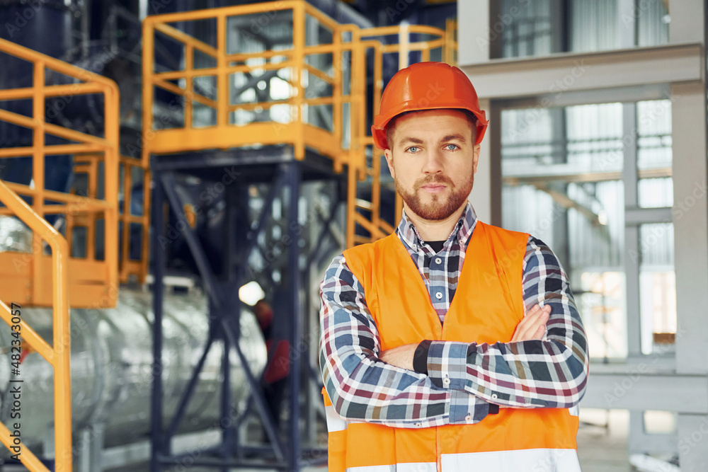 Looking forward. Construction worker in uniform is in the factory Looking forward. Construction worker in uniform is in the factory