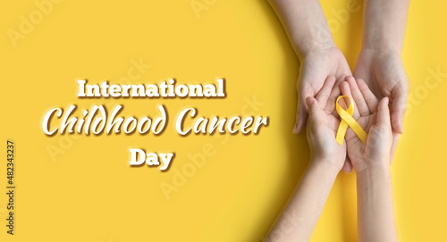 International Childhood Cancer Day. Mom and baby holding yellow ribbon in their hands. Sarcoma Awareness, Bone cancer, childhood cancer awareness. Concept I Am and I Will. banner photo