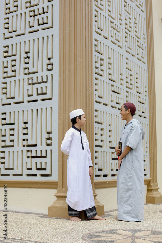 Two islamic boarding school students talking during a study break around the mosque