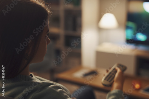 Woman sitting on the couch and watching TV