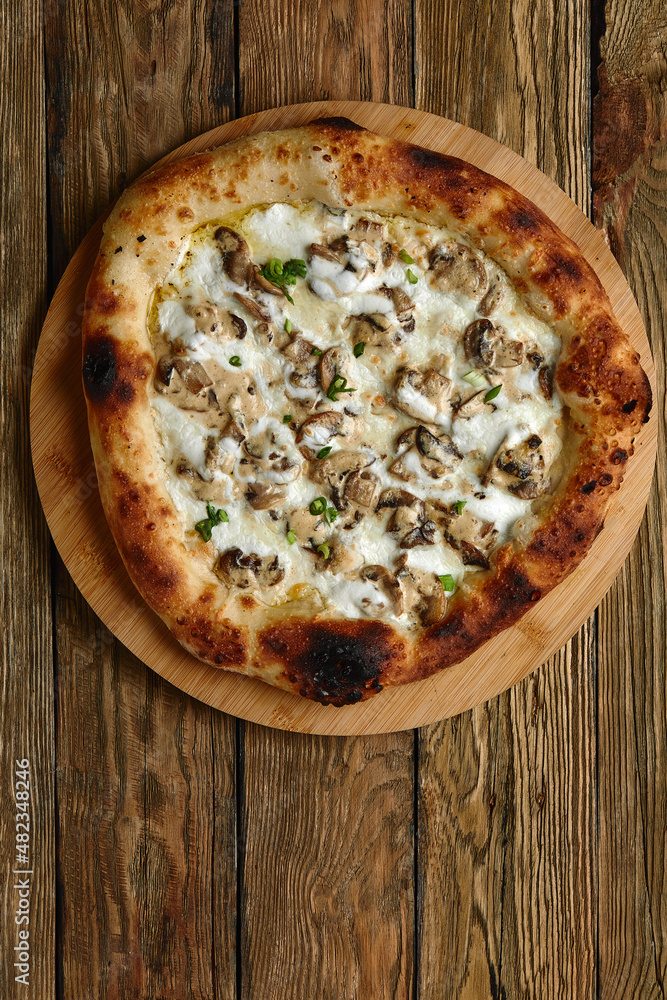 Appetizing pizza with mushrooms on a wooden tray Appetizing pizza with mushrooms on a wooden tray