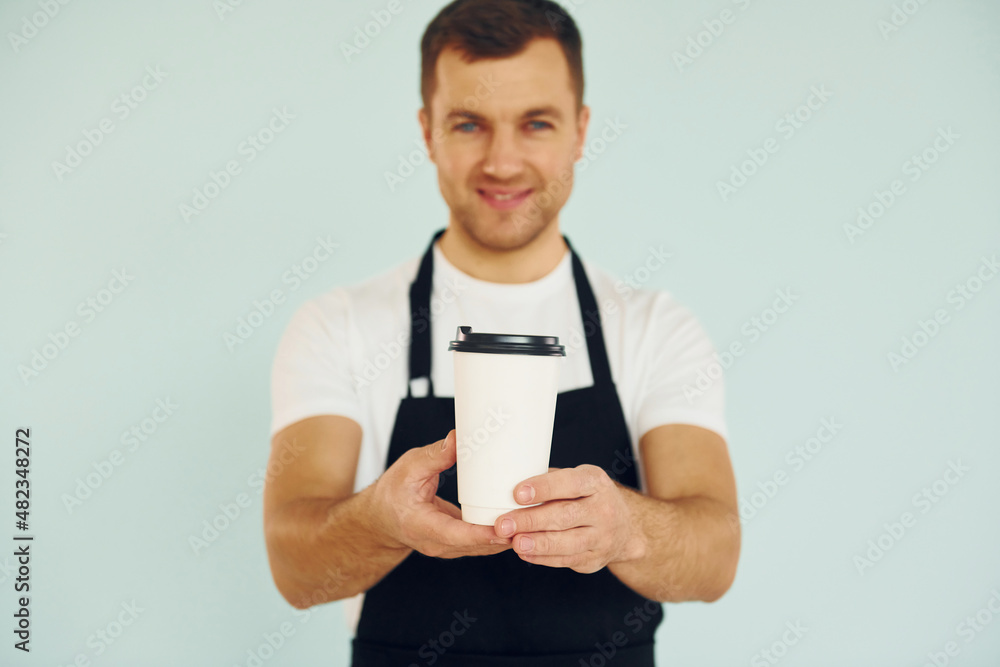 Man in uniform standing in the studio with drink in hands