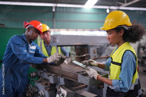 Portrait of Professional Heavy Industry Engineer / Worker Wearing Safety Uniform, Goggles and Hard Hat. In the Background Unfocused Large Industrial Factory © FotoArtist