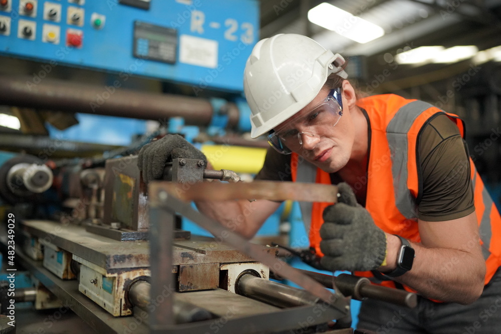 Portrait of Professional Heavy Industry Engineer / Worker Wearing Safety Uniform, Goggles and Hard Hat. In the Background Unfocused Large Industrial Factory Portrait of Professional Heavy Industry Engineer / Worker Wearing Safety Uniform, Goggles and Hard Hat. In the Background Unfocused Large Industrial Factory