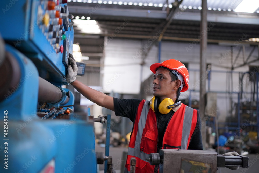 Portrait of Professional Heavy Industry Engineer / Worker Wearing Safety Uniform, Goggles and Hard Hat. In the Background Unfocused Large Industrial Factory Portrait of Professional Heavy Industry Engineer / Worker Wearing Safety Uniform, Goggles and Hard Hat. In the Background Unfocused Large Industrial Factory