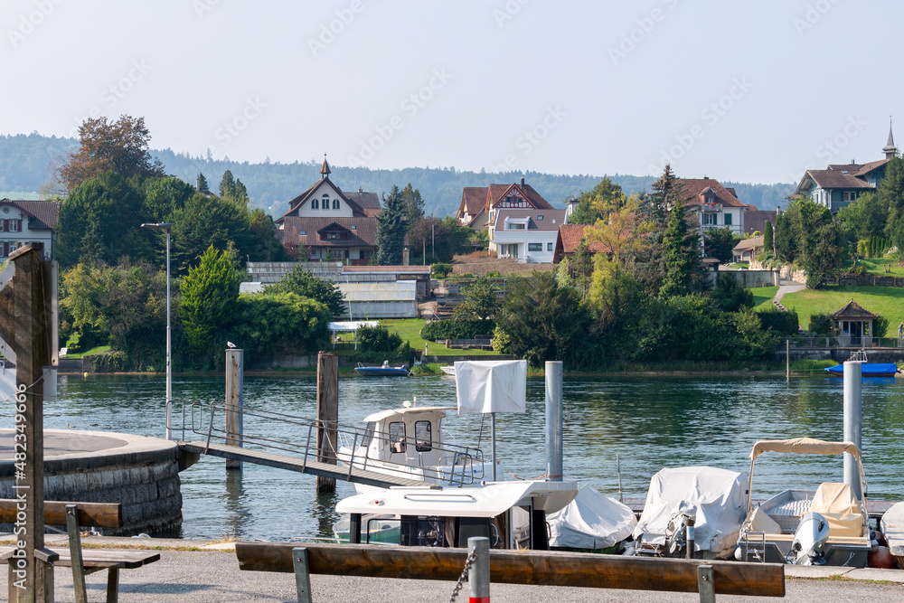 Ships and boats on the Rhine river in Stone at the Rhein town in the background on sunny summer day
