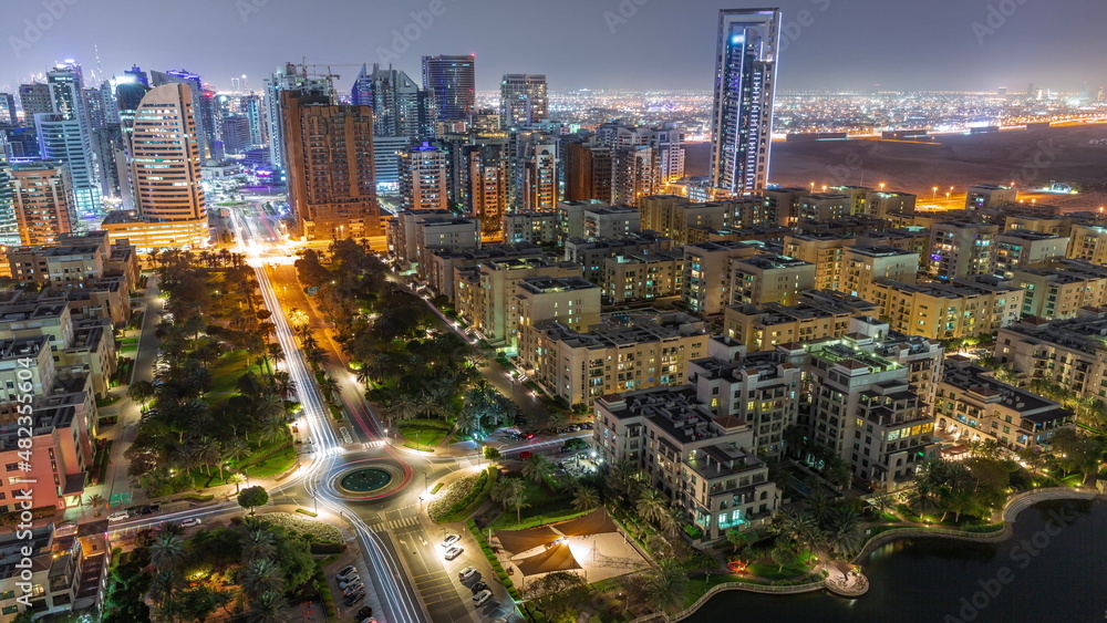 Obraz premium Skyscrapers in Barsha Heights district and low rise buildings in Greens district aerial all night timelapse.