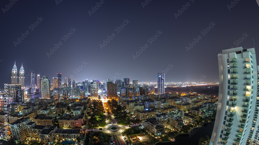 Panorama with skyscrapers in Barsha Heights district and low rise buildings in Greens district aerial all night timelapse.