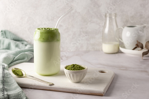 Homemade dalgona matcha latte, and spoon of green tea powder. photo