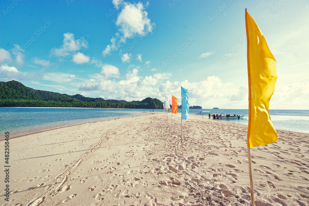 Beautiful landscape. White sand beach with colorful flags on it. Siargao Island, Philippines.