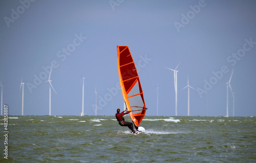 Windsurfing at Lake IJssel with the wind turbine park Fryslan in background (Netherlands) photo