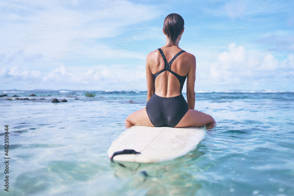 Hobby and vacation. Young sexy woman swimming over surfboard in clear blue water at beach, Siargao Island, Philippines. Hobby and vacation. Young sexy woman swimming over surfboard in clear blue water at beach, Siargao Island, Philippines.