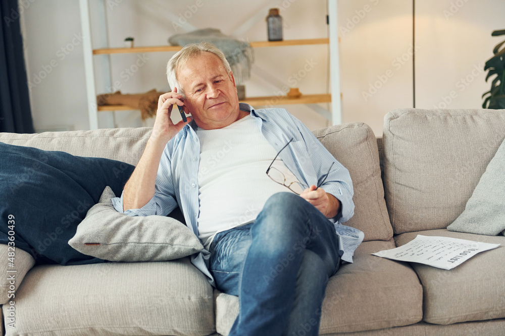 Talking by phone. Senior man in nice clothes is at home Talking by phone. Senior man in nice clothes is at home