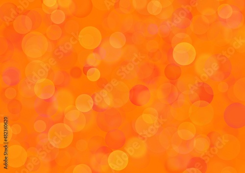 Blurred pink background with bright orange circle sparkling lights. Shiny red glittery bokeh of christmas garland.