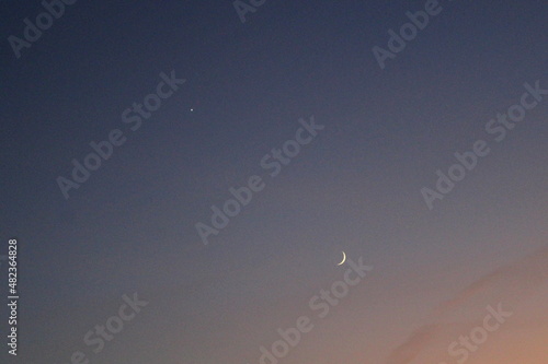 Moon and star in the evening sky.