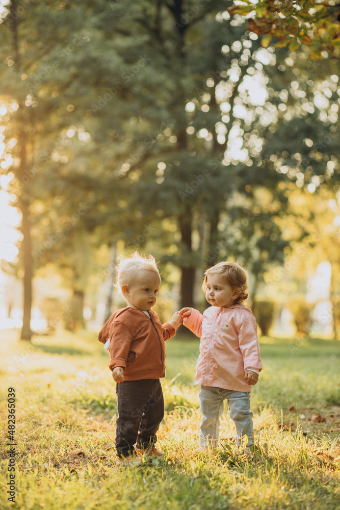 Cute little boy and girl together in autumnal park Cute little boy and girl together in autumnal park