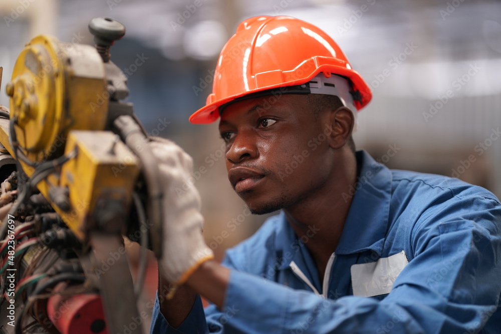 Portrait of Professional Heavy Industry Engineer / Worker Wearing Safety Uniform, Goggles and Hard Hat. In the Background Unfocused Large Industrial Factory Portrait of Professional Heavy Industry Engineer / Worker Wearing Safety Uniform, Goggles and Hard Hat. In the Background Unfocused Large Industrial Factory