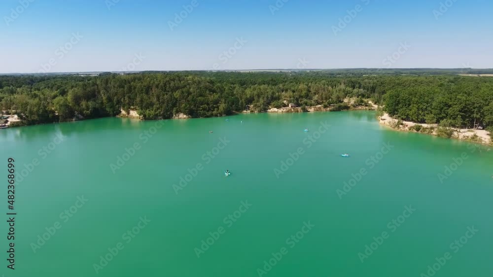 Beautiful scenery of a blue lake surrounded by rocky bank with green forests. Blue skies reflecting in the water. Aerial view. Beautiful scenery of a blue lake surrounded by rocky bank with green forests. Blue skies reflecting in the water. Aerial view.