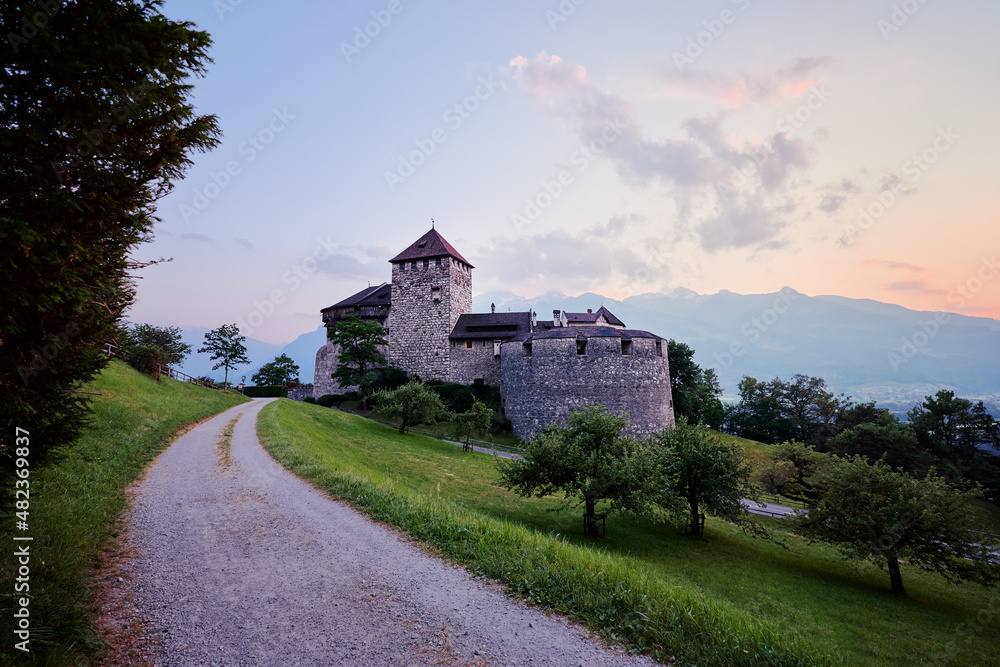 Fototapeta premium Vaduz Castle, the official residence of the Prince of Liechtenstein, with Alps mountains in background on sunset.