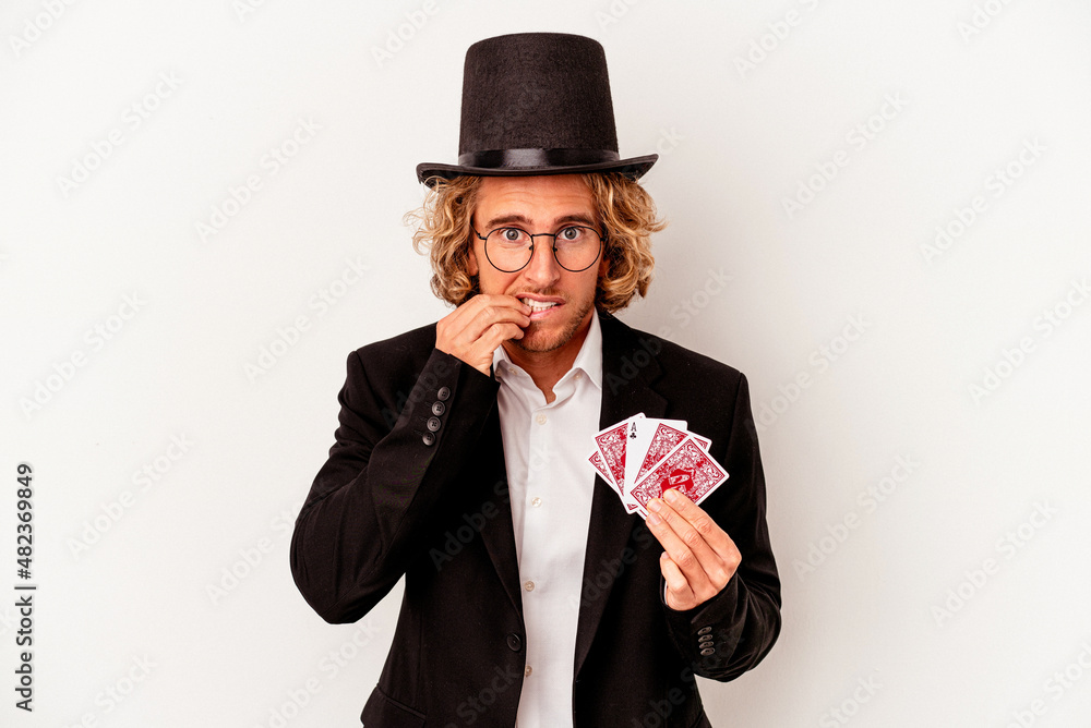 Young magician caucasian man holding magic cards isolated on white background biting fingernails, nervous and very anxious. Young magician caucasian man holding magic cards isolated on white background biting fingernails, nervous and very anxious.