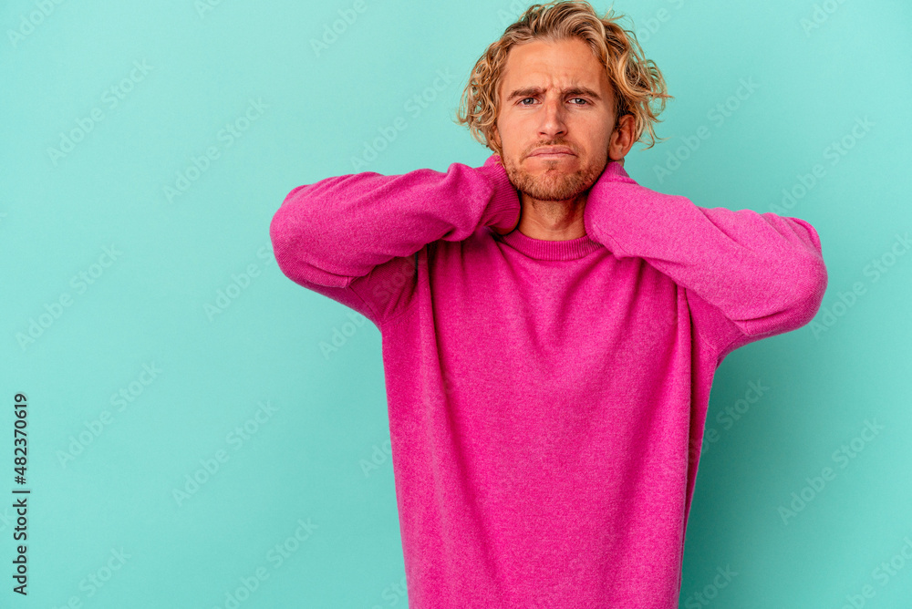 Young caucasian man isolated on blue background touching back of head, thinking and making a choice. Young caucasian man isolated on blue background touching back of head, thinking and making a choice.