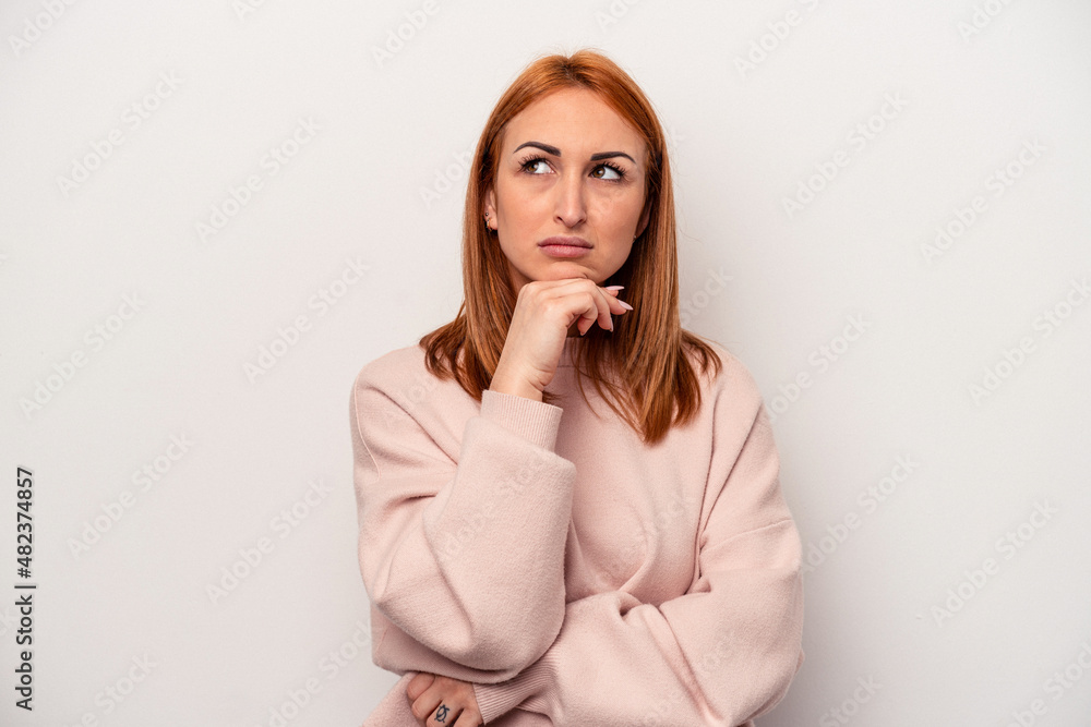Young caucasian woman isolated on white background suspicious, uncertain, examining you. Young caucasian woman isolated on white background suspicious, uncertain, examining you.