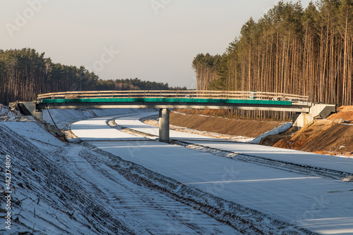 construction of a bridge in winter over the expressway in the forest