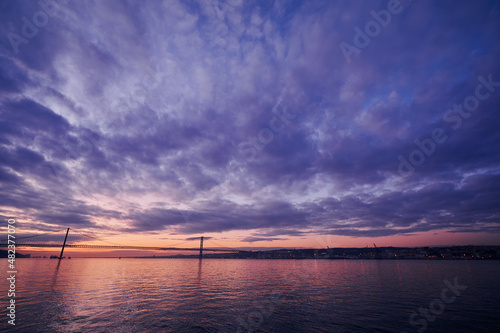 Beautiful landscape with suspension 25 April bridge bridge over the Tagus river in Lisbon at sunset.