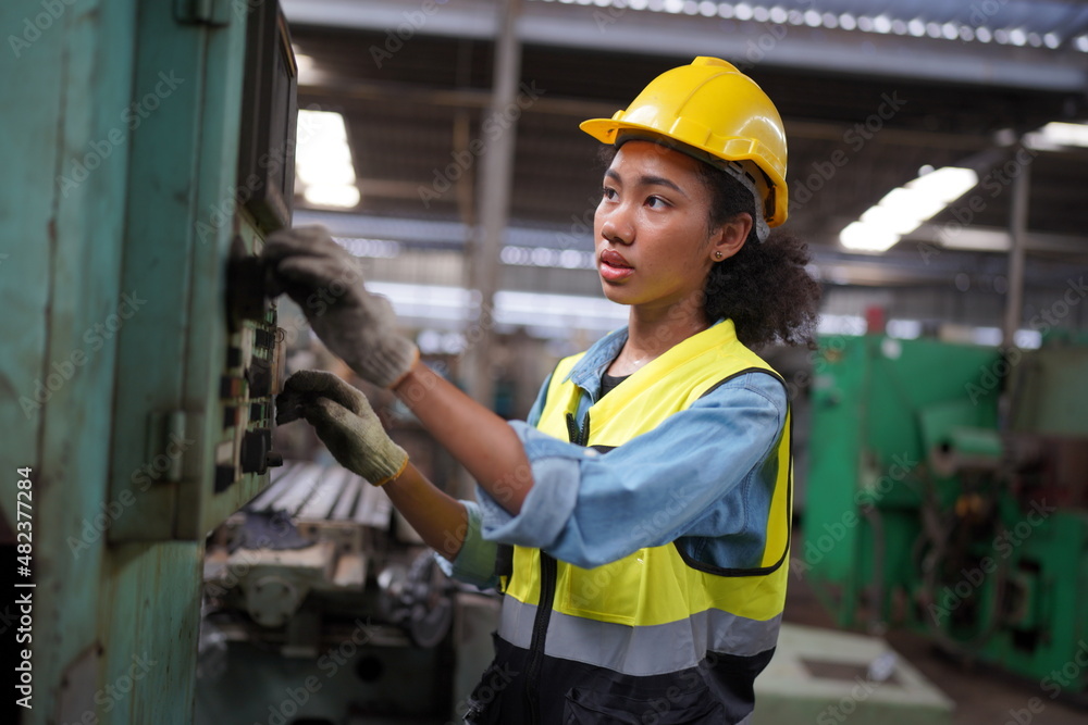 Female apprentice in metal working factory, Portrait of working female industry technical worker or engineer woman working in an industrial manufacturing factory company. Female apprentice in metal working factory, Portrait of working female industry technical worker or engineer woman working in an industrial manufacturing factory company.