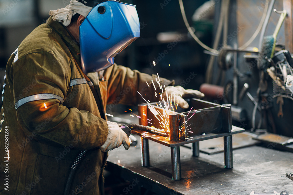 Welder welding metal steel industrial part construction on factory. Welder welding metal steel industrial part construction on factory.