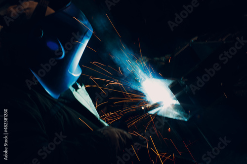 Welder welding metal steel industrial part construction on factory.