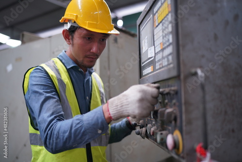 Male engineer metalworker industrial experienced operator technician worker in safety hard helmet working on lathe machine, professional man in industry technology manufacturing factory workshop © FotoArtist