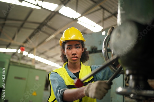 Female apprentice in metal working factory, Portrait of working female industry technical worker or engineer woman working in an industrial manufacturing factory company.