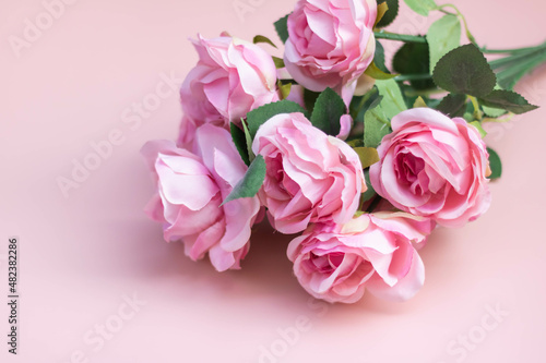 Pink rose bouquet on a light pink background.