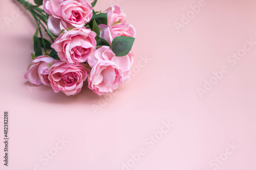 Pink rose bouquet on a light pink background.