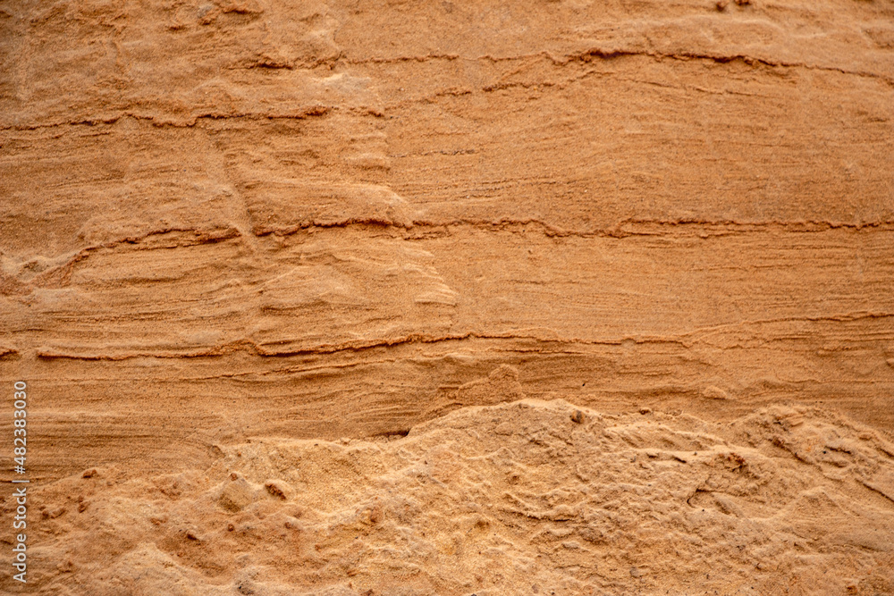Textural sand, with relief surface, multi-colored layers and different in size of granules, in outdoor sand career, after mining ore and sand for construction. Textural sand, with relief surface, multi-colored layers and different in size of granules, in outdoor sand career, after mining ore and sand for construction.