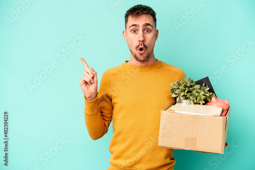 Young caucasian man making a move isolated on blue background pointing to the side