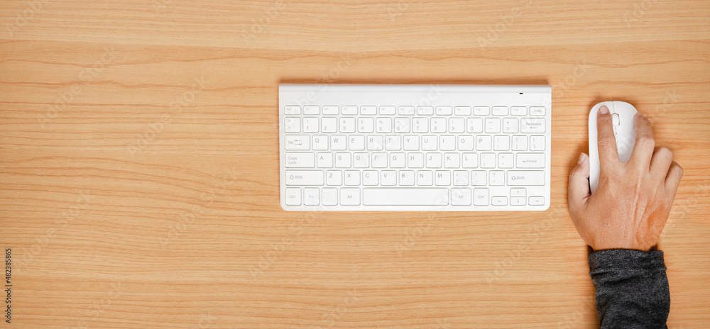 Man using mouse and computer keyboard on wooden table free text copy space. Man using mouse and computer keyboard on wooden table free text copy space.