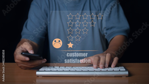 Man use smartphone and keyboard computer choosing sadness emotion face screen. bad service dislike bad quality, low rating, social media not good. Concept of customer experience dissatisfied.
