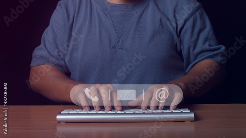 Businessman using computer keyboard with icon call phone, email and address. Customer support service contact us people connection concept.