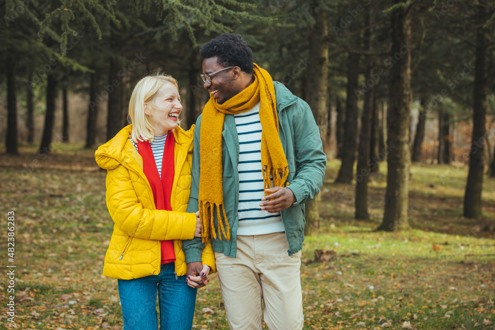 Fototapeta premium Young couple in love walking on pathway through grass field. Young couple on vacation , they enjoy in summer. They walking through forest, exploring nature