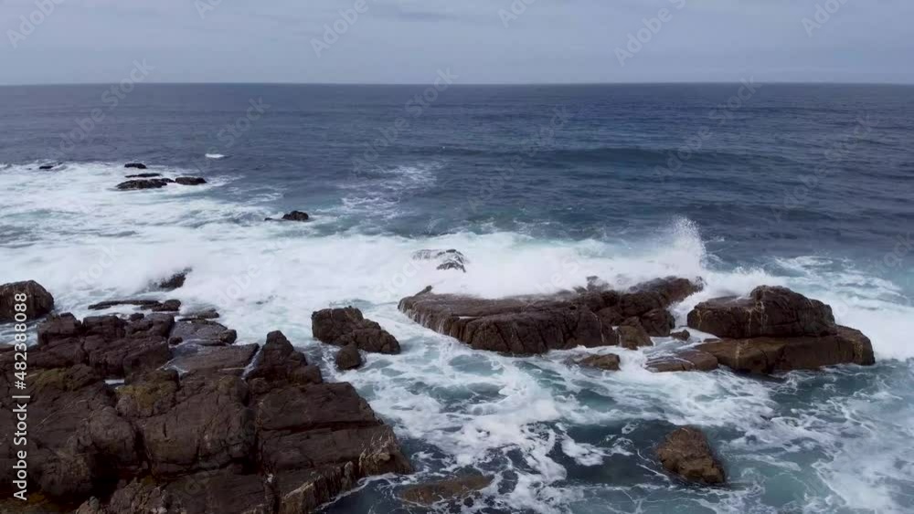 Deep blue sea and waves rolling onto the rocky shore camera facing out to sea on a cloudy day 60 fps Deep blue sea and waves rolling onto the rocky shore camera facing out to sea on a cloudy day 60 fps
