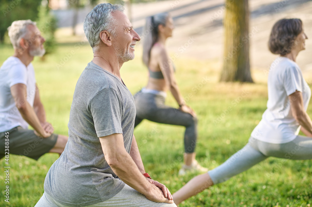 Group of mid aged people having a workout in the park Group of mid aged people having a workout in the park
