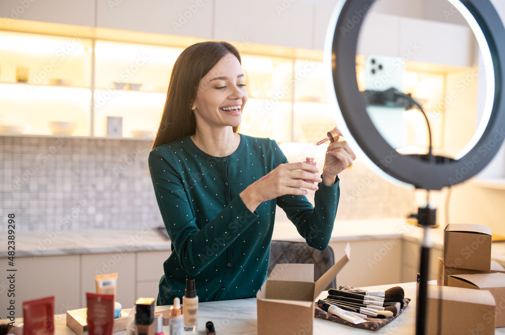 Young woman applying sample of new toning cream on her hand Young woman applying sample of new toning cream on her hand