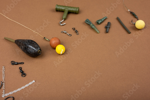 Carp fishing gear close up on the brown backdrop. Fishing tackle concept in the studio. Copy space photo