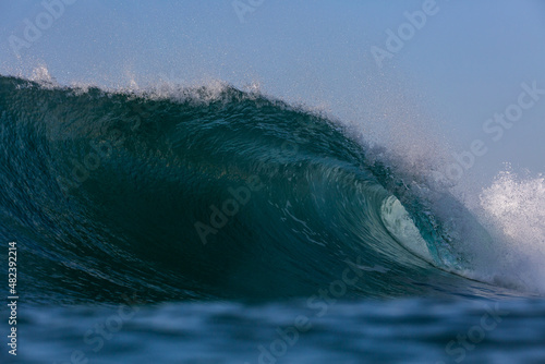 perfect blue wave crashing on a reef